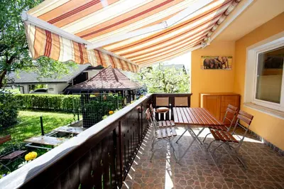 a balcony with a table and chairs and a gazebo at Hostel LakeBled in Bled