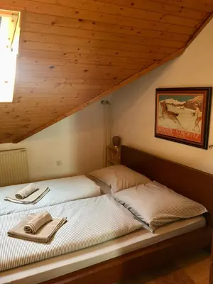 two beds in a room with wooden ceilings at Stay Apartments Bled in Bled
