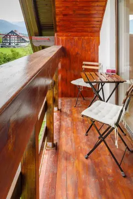a porch with a bench and a table and chairs at Apartment Ana in Bohinj