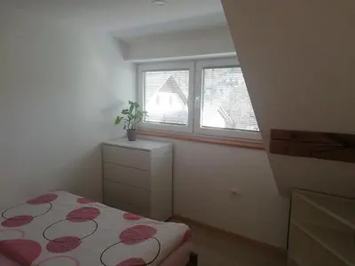 a small bedroom with a bed and a window at Apartment Ana in Bohinj