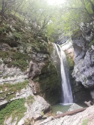 a waterfall on the side of a rocky mountain at Apartment Ana in Bohinj