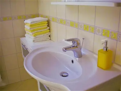 a white sink in a bathroom with towels at APARTMA PR TAVČARJU in Zgornje Gorje