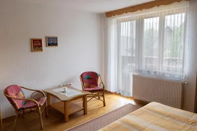a room with a table and two chairs and a bed at APARTMA PR TAVČARJU in Zgornje Gorje