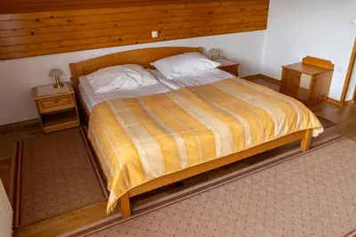 a bedroom with a large bed with a wooden headboard at APARTMA PR TAVČARJU in Zgornje Gorje