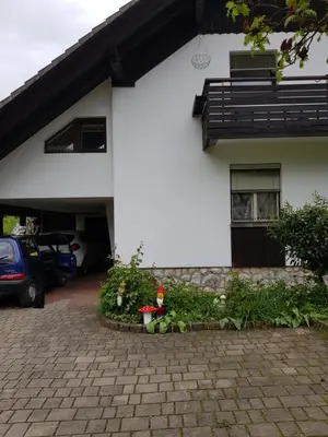 a white house with a car parked in front of it at Apartma Take It Easy in Bled