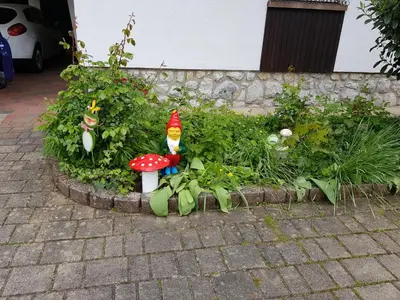 a garden with a gnome sitting on a mushroom at Apartma Take It Easy in Bled