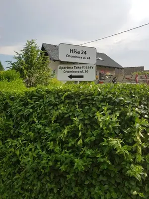 a street sign in front of a hedge at Apartma Take It Easy in Bled