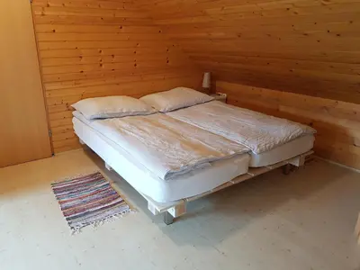 a bed in a room with a wooden wall at Apartma Take It Easy in Bled