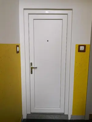 a white door in a room with a yellow wall at Bonito apartment in Postojna
