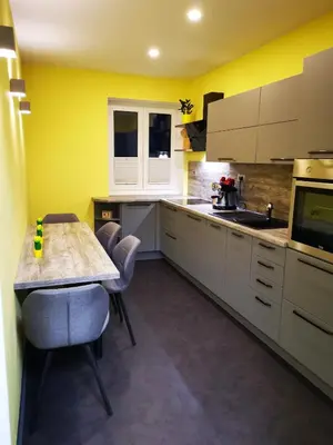 a kitchen with yellow walls and a table and chairs at Bonito apartment in Postojna