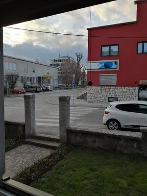 a white car parked in front of a parking lot at Bonito apartment in Postojna