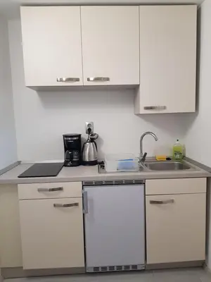 a kitchen with white cabinets and a sink at Apartment Dolce Vita in Celje
