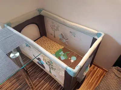 a baby crib with a bed in a room at Apartment Dolce Vita in Celje