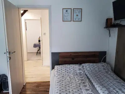 a bedroom with a bed and a door leading to a hallway at Apartment Dolce Vita in Celje