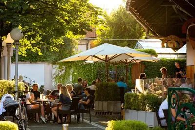 a group of people sitting at tables in a restaurant at Pri Žabarju Bed & Breakfast Ljubljana in Ljubljana