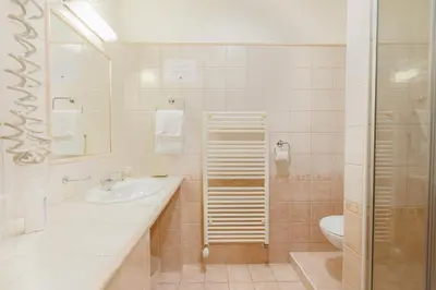 a white bathroom with a sink and a toilet at Pri Žabarju Bed & Breakfast Ljubljana in Ljubljana