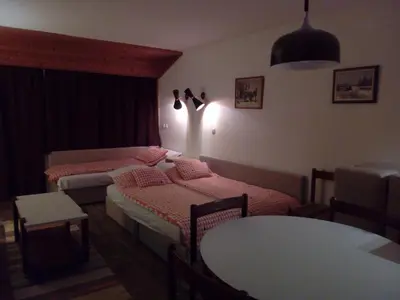a room with two beds and a table in it at Apartman Veriga in Kranjska Gora