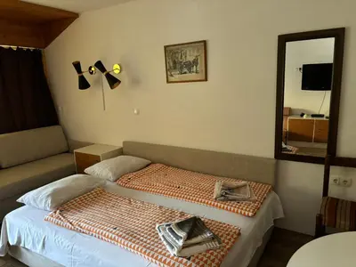a small bedroom with a bed and a mirror at Apartman Veriga in Kranjska Gora