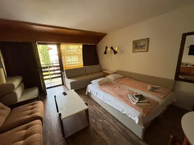 a small bedroom with a bed and a couch at Apartman Veriga in Kranjska Gora