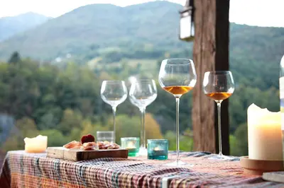 a table with wine glasses and a plate of food at Klavze 28 in Most na Soči