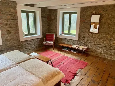 a bedroom with a bed and two windows at Klavze 28 in Most na Soči