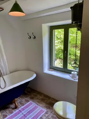 a bathroom with a tub and a window at Klavze 28 in Most na Soči