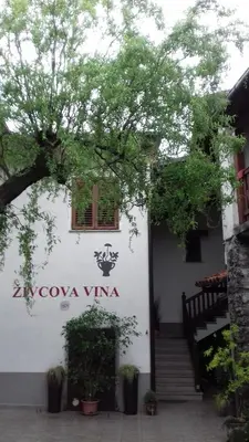 a building with a sign on the side of it at Apartmaji pri Živcovih in Dutovlje