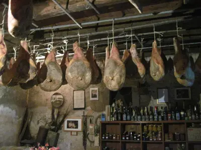 a bunch of meat hanging on the wall of a bar at Apartmaji pri Živcovih in Dutovlje