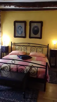 a bedroom with a bed with two pictures on the wall at Apartmaji pri Živcovih in Dutovlje