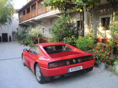 a red car parked in front of a building at Apartmaji pri Živcovih in Dutovlje