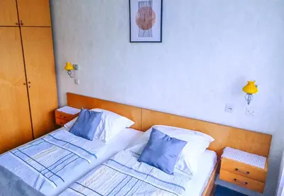 a bedroom with two beds with blue and white pillows at Guest House Ivanka in Bled