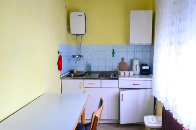 a small kitchen with a table and a sink at Guest House Ivanka in Bled