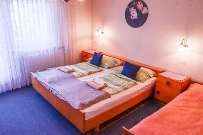 a bedroom with a large bed with blue pillows at Guest House Ivanka in Bled