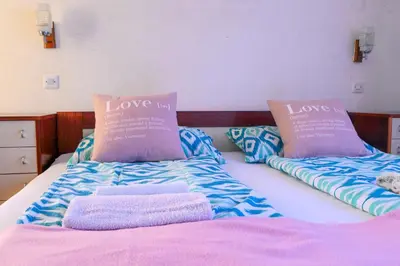 a bed with two pillows and towels on it at Guest House Ivanka in Bled