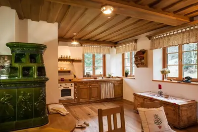 a kitchen with wooden cabinets and a table in a room at Alpine Homestead in Goreljek
