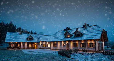 a house covered in snow at night at Alpine Homestead in Goreljek