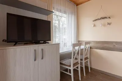 a living room with a flat screen tv on a cabinet at Apartments Kot'č in Kranjska Gora