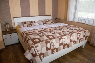 a bedroom with a bed with a brown and white blanket at Apartments Kot'č in Kranjska Gora