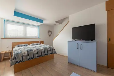 a bedroom with a bed and a flat screen tv at Apartments Kot'č in Kranjska Gora