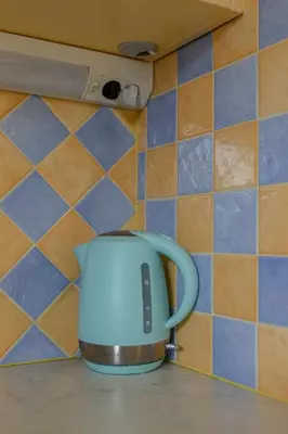 a blue tea kettle sitting on a kitchen counter at Apartments Kot'č in Kranjska Gora
