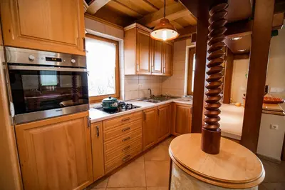 a kitchen with wooden cabinets and a large window at Holiday Home Mirt with HotTub & Sauna in Blanca