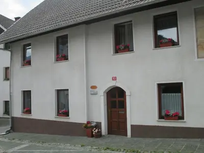 a building with flowers in the windows and a door at Apartments Pr'Krštano in Kranjska Gora