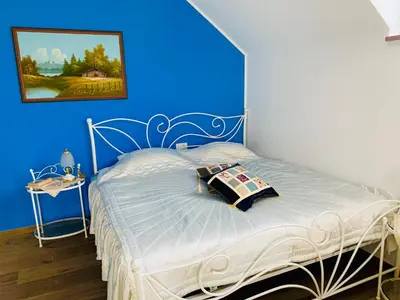 a bedroom with a bed with a blue wall at STATUS Apartments in Bled