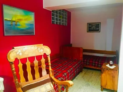 a red room with a chair and a bed at STATUS Apartments in Bled