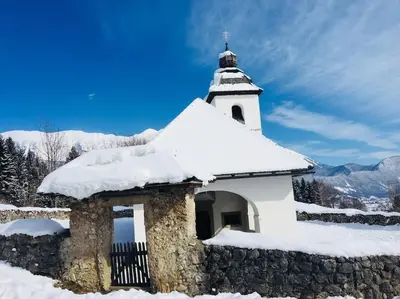 a white church with snow on top of it at STATUS Apartments in Bled