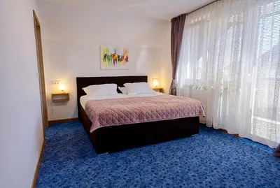 a bedroom with a large bed with white pillows at APARTMENT PETEK in Bled