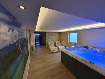 a bathroom with a large blue tub in a room at APARTMENT PETEK in Bled