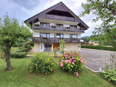 a large house with flowers in the yard at APARTMENT PETEK in Bled
