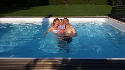 a man and a woman are in a swimming pool at Vila Anna in Radenci