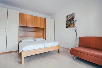a bedroom with a bed and a red couch at Vila Anna in Radenci